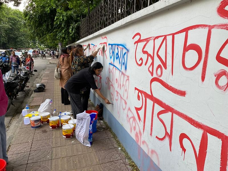 দেয়ালে আওয়ামী লীগ সরকার পদত্যাগের আন্দোলনে লেখা স্লোগান মুছে ফেলছেন শিক্ষার্থীরা। মিন্টো রোড এলাকা, ঢাকা, ০৭ আগস্ট